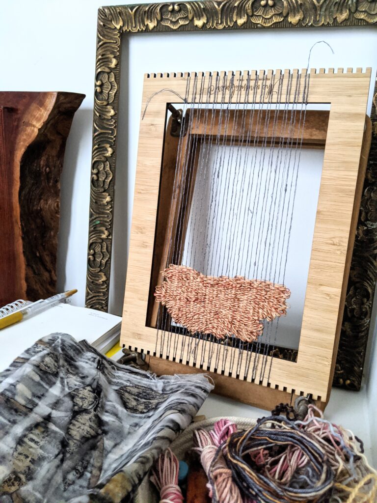 A photo of my first attempt to weave a project that failed. This picture shows weaving on a lap loom.