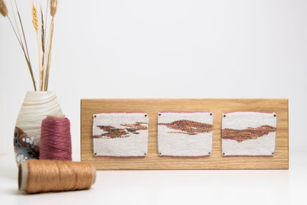 A triptych of winter tapestries mounted to a block of timber